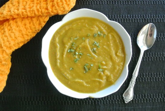 Vegan Split Pea Soup from an above head photo looking down at creamy splut pea soup in a white bowl on a black mat.