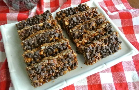 Chewy Chocolate Chip Bars are lined up in two rows on a white square plate.