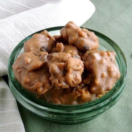 Black Walnut Pralines are piled in a green glass bowl on a green mat.