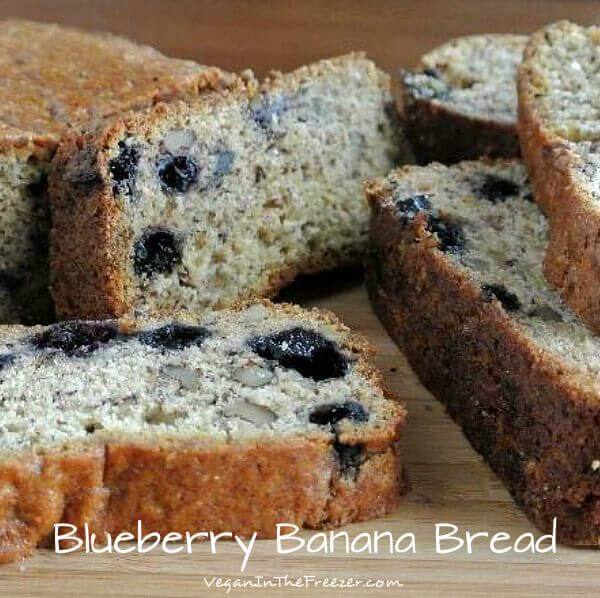 Blueberry Banana Bread is a close photo of the inside cut of the banana bread with many slices tilited and piled on each other.