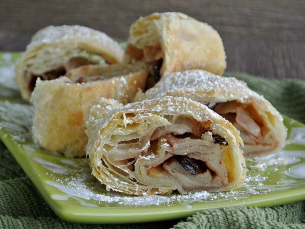 Straight on view of thick slices of strudel laying in all directions on a lime green plate.