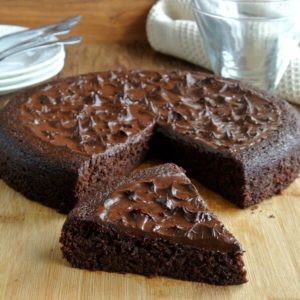 Decadent Chocolate Torte if one exotic layer with a chocolate topping. A single slice is pulled out and sitting in front.