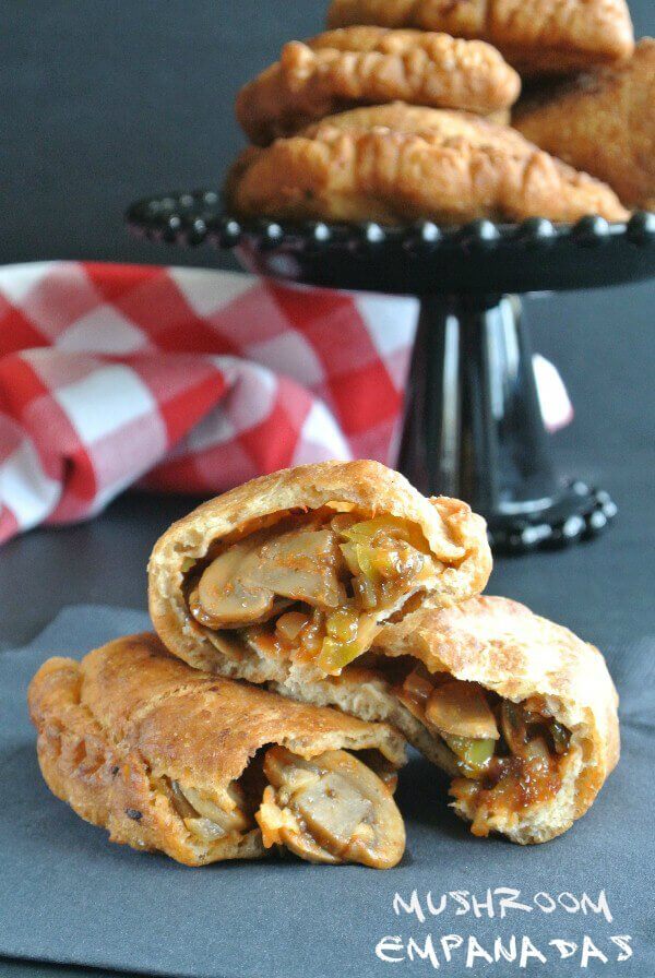 Mushroom Empanadas are homemade dough/crust wrapped around a moist mushtoom mixture. The empanadas are stacked in half to show the delicious insides.