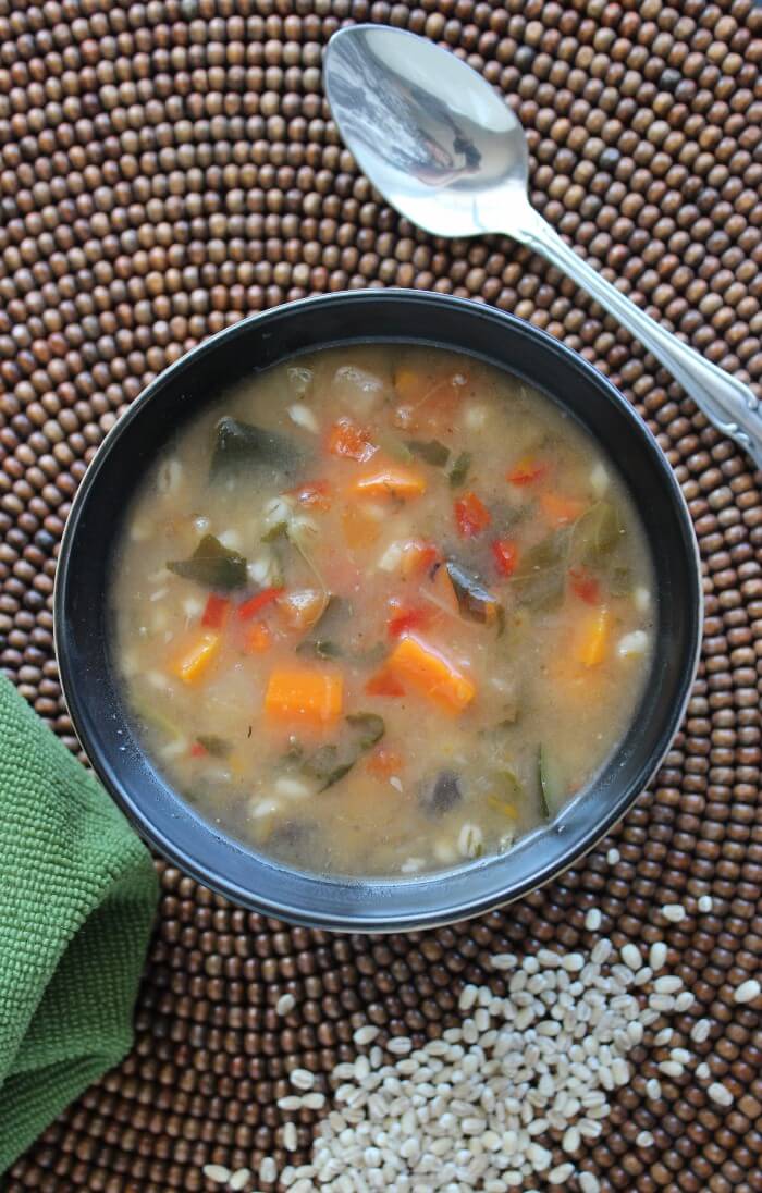 Vegetable Barley Soup in an overhead photo of a rich brothy soup showing vegetables.