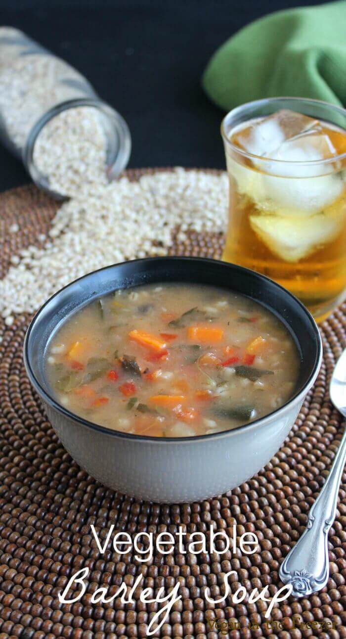 Vegetable Barley Soup in a side view of the rich brothy soup with text above.