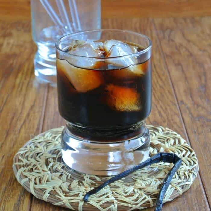 Glass of sweet liquor sitting on a woven coaster.