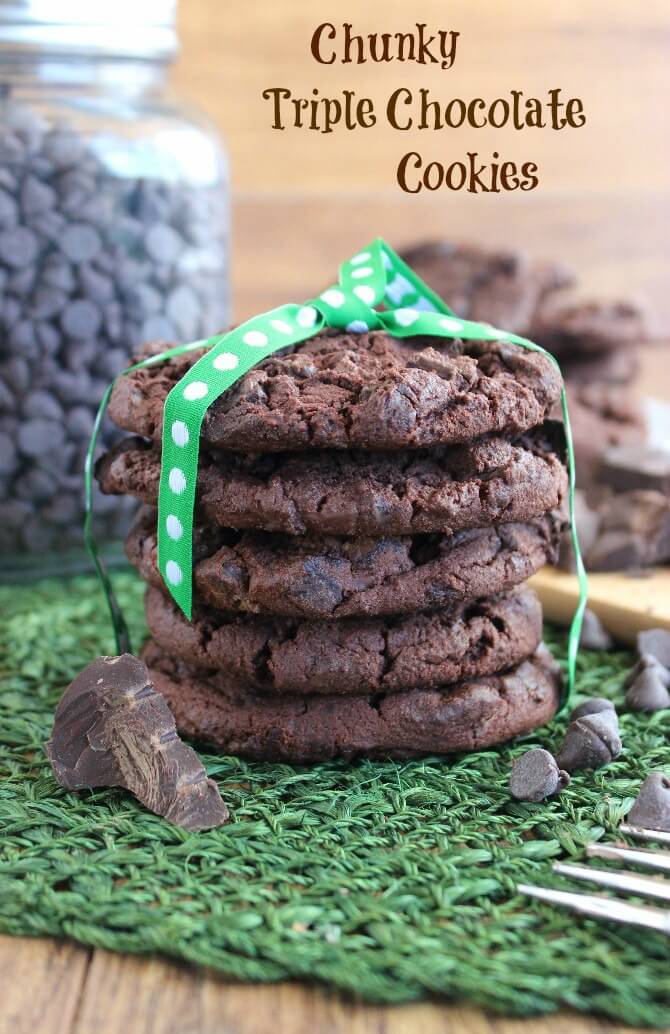 Triple Chocolate Cookies are stacked high with a green ribbon tied up and over.