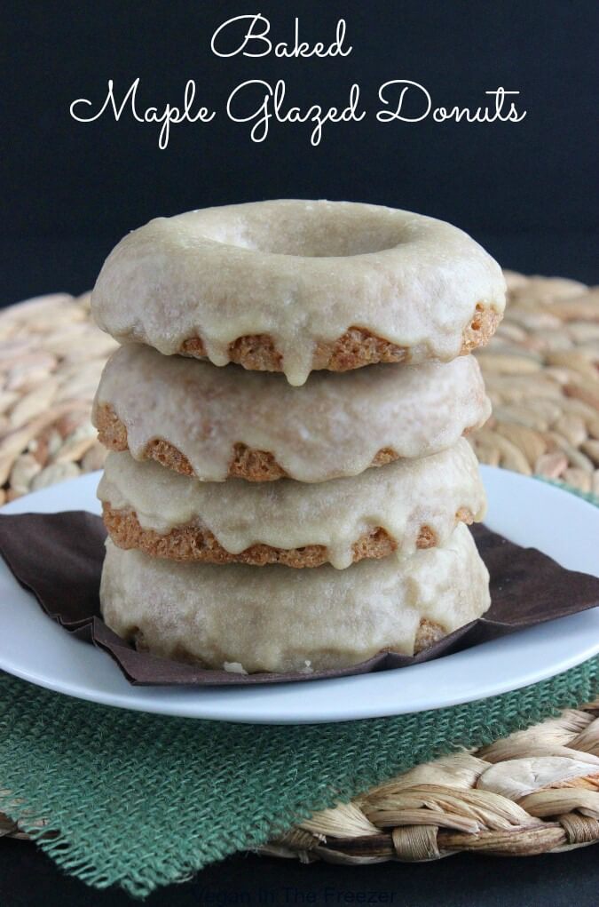Maple Glazed Donuts are stacked four high on a chocolate napkins a top a white plate. Each donut has a thick layer of maple icing dripping down their sides.