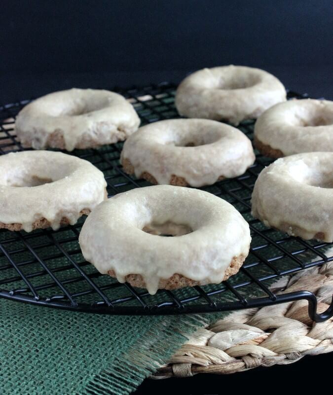 Breakfast treats are spread across brown and green napkins and a woven mat.