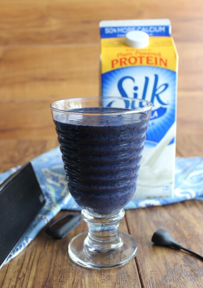 Blueberry smoothie sitting in front of a silk carton of dairy free milk.