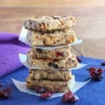 Cranberry Date Breakfast Bars stavked six squares high with fruit showing at the sides.