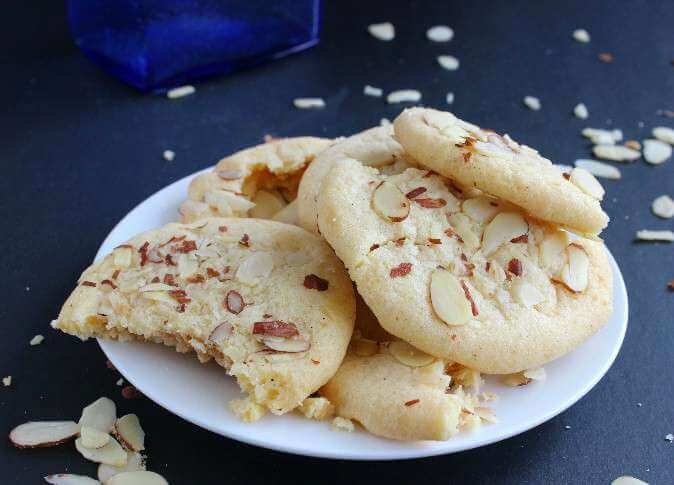 Chinese Almond Butter Cookies in a wide photo with one cookie broken open.
