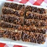 Chewy chocolate chip bars are lined up in two rows on a white square plate.