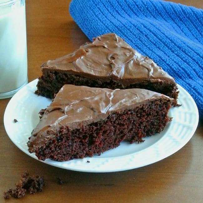 Two tirnalges of chocolate cake on a white plate.