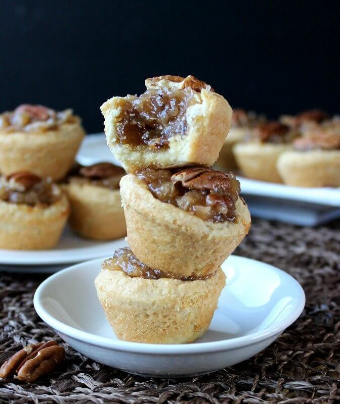 Three mini pecan tarts stacked on top of each other.