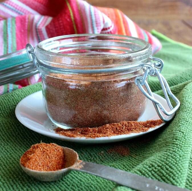 Homemade Chili Seasoning Mix fills a pint canning jar with a tablespoon on the side.