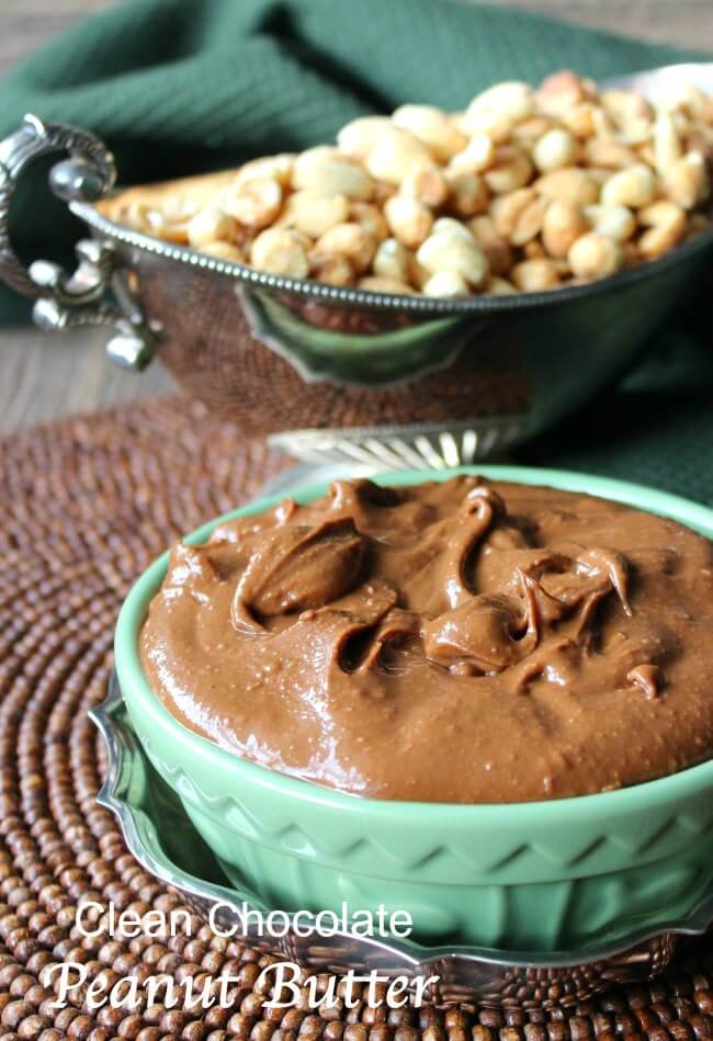 Chocolate spread in a green bowl with peanuts behind.