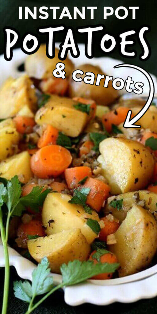 Ascallopedwhite bowl full of potatoes and carrots in large chunks and sprinkled with parsley.