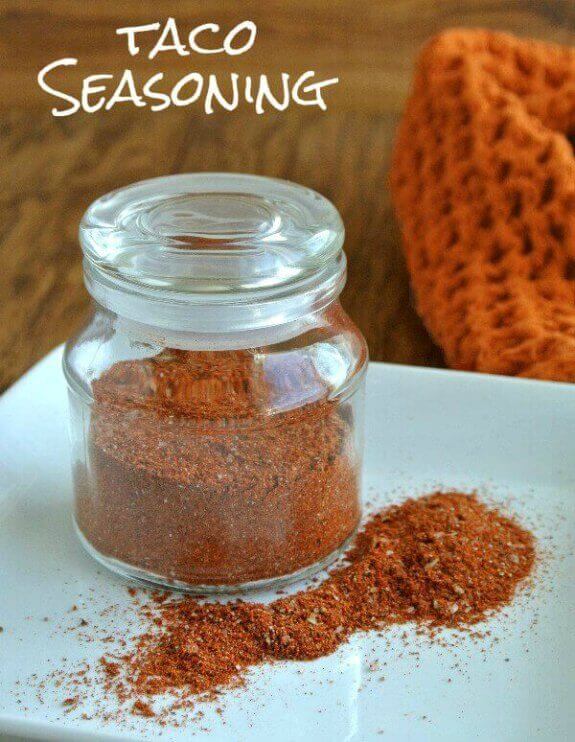 Homemade Taco Seasoning in a rich color that you can see through a glass lidded jar.