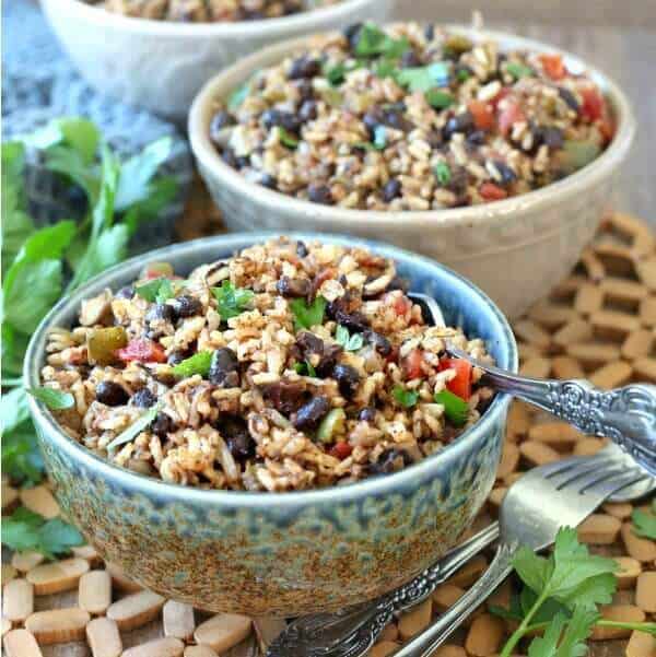 Acadian Black Beans and Rice optimized for social media shares in a square photo. Colorful black beans and rice mixed with red bells and sprinkled with green parsley.