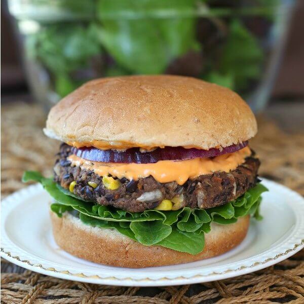 A Black Bean Burger layered with lettuce, onion and condiments.