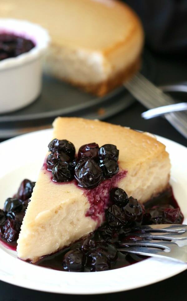 Dairy Free New York Cheesecake all plated up and ready. Fork ready and covered with blueberry sauce.
