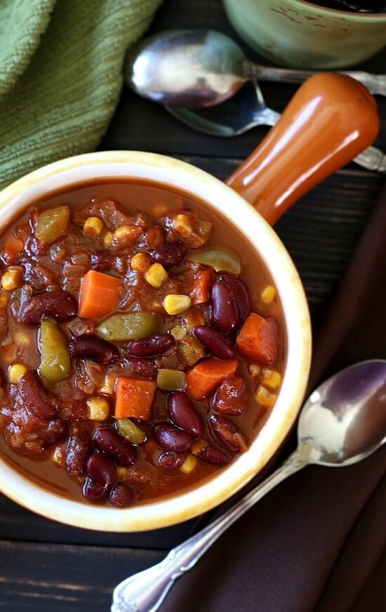 is being looked at from above and shows rich bean chili with added carrots, corn and pepper. So colorful!!