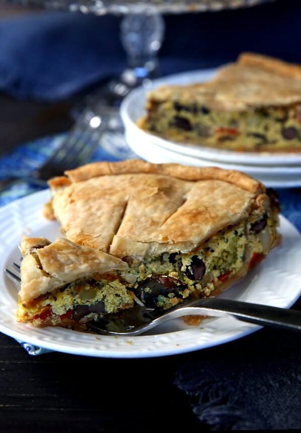 A nice forkful of savory pie is served up from a white plate.