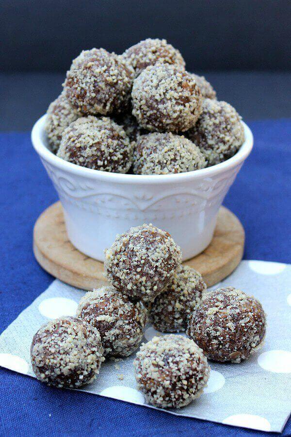 Kahlua Truffles are piled in a white bowl against a navy blue background. 