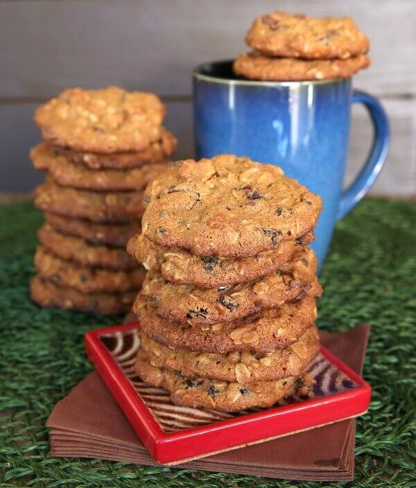 Cranberry Orange Cookies are stacked high on a red square pottery coaster.