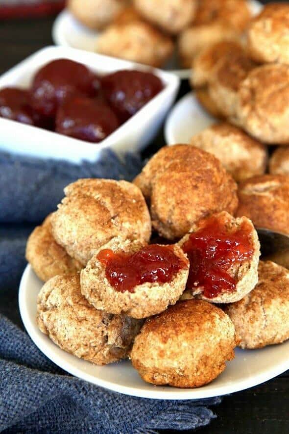 Cinnamon Cookie Biscuits are little fat biscuits with a cinnamon sugar flare. Stacked on a white plate with one open and dolloped with strawberry jam.