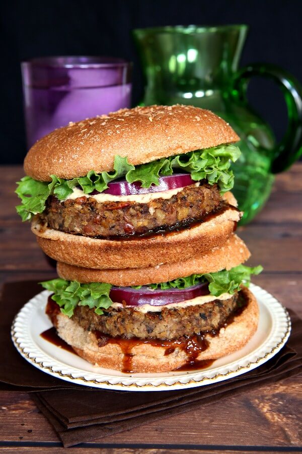 Vegan Mushroom Pecan Burgers are stacked double high and oozing with hoison sauce and big fat patties