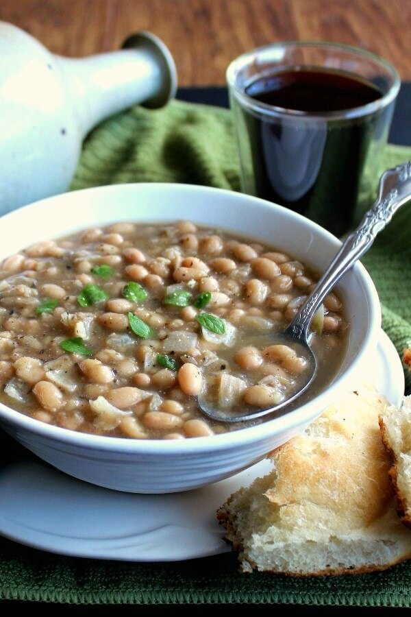 White Bean Chili is tilted forward with a spoon ladling the beans and broth up for a big bite.