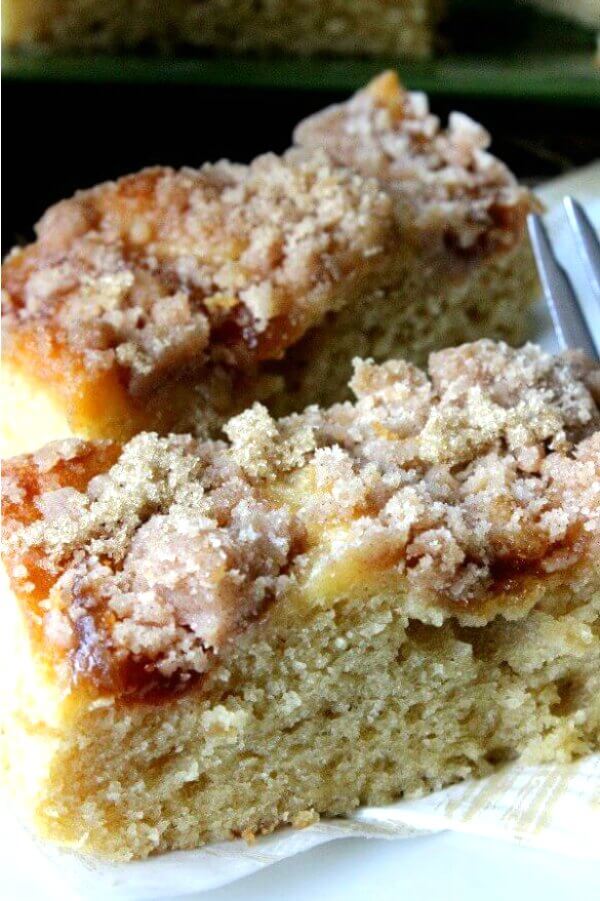 Vegan Coffee Cake with Apple Cinnamon Streusel is cut into two rectangles with a very up-close and personal photo of the sweet temping cinnamon streusel and moist coffee cake.