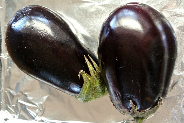 Baba Ganoush Dip is made from eggplant and here is a photo of two eggplants laying on foil waiting to be roasted.