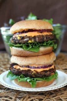 A stack of burgers filled with veggies filled patties.