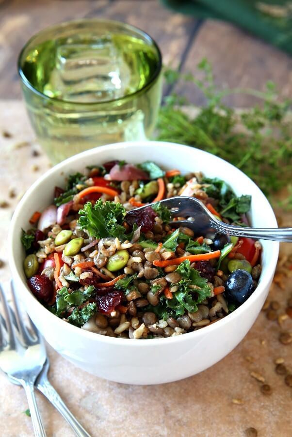 Superfood Salad with Maple Vinaigrette is in a white bowl and tilted forward so we can see eleven superfoods mixed together and glistening.