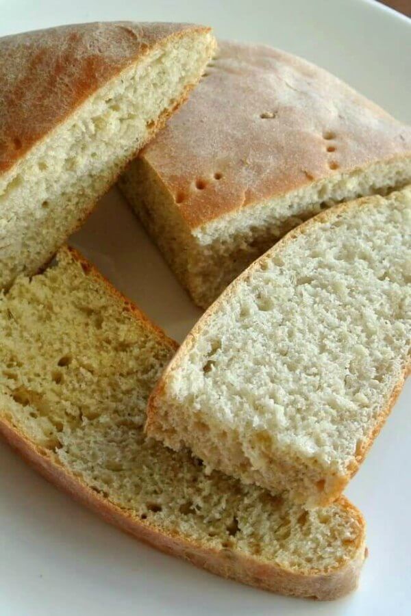 Sage Dill Bread is sliced into half pieces and they are lying every which way on top of each other.