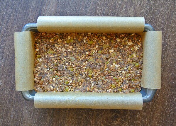 Vegan Meatloaf with Chickpeas, Green Split Peas and Mushrooms is mixed with all of the ingredients and packed into a baking loaf pan. Parchment is hanging over the edges for easy removal.