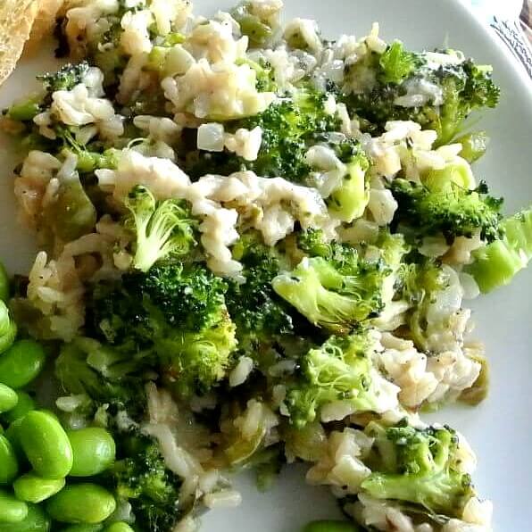 Vegan Broccoli Rice Casserole is a close-up square picture with broccoli, rice and dairy-free cheese on a white plate.