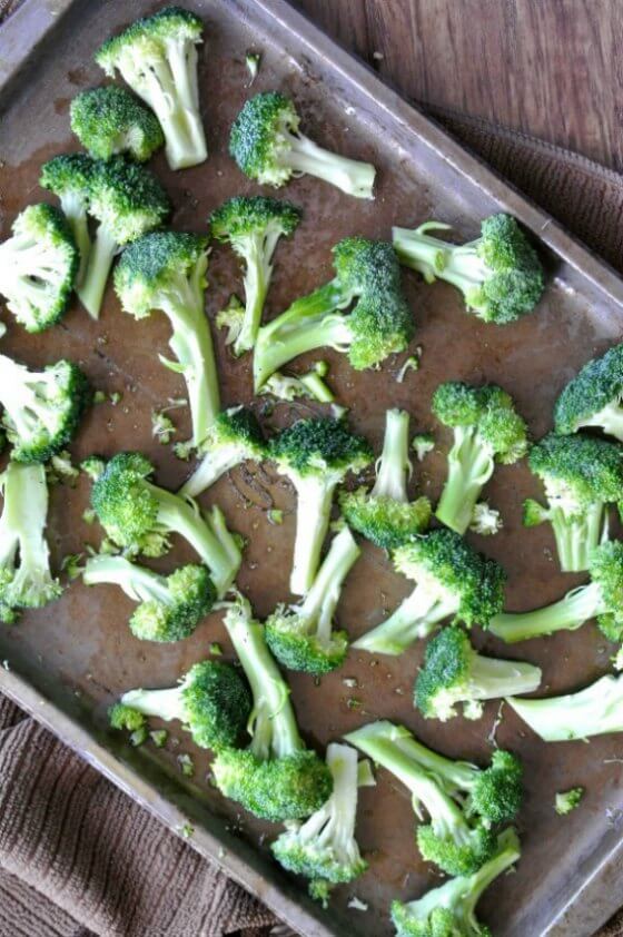 Balsamic Roasted Broccoli is scattered on a baking sheet with seasoning included with roasting just ahead.