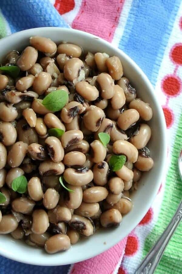 Close-up view of a bowlful of beans against a colorful cloth.