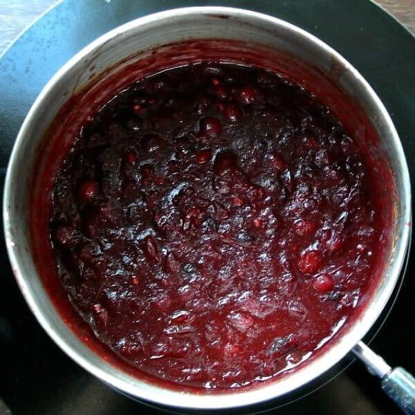An overhead view of the cooked cranberry sauce in a saucepan.