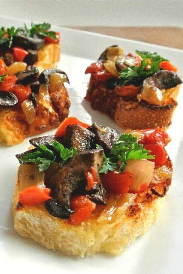 Mushroom Bruschetta Crostini has one centered toast topped with mushrooms, bell peppers and onions.