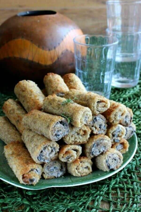 Rolled Toasted Mushroom Appetizers are high into a pyramid just waiting to be eaten.