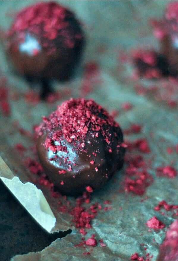 One huge glistening Raspberry Dusted Chocolate Fudge Brownie Truffles right in front.