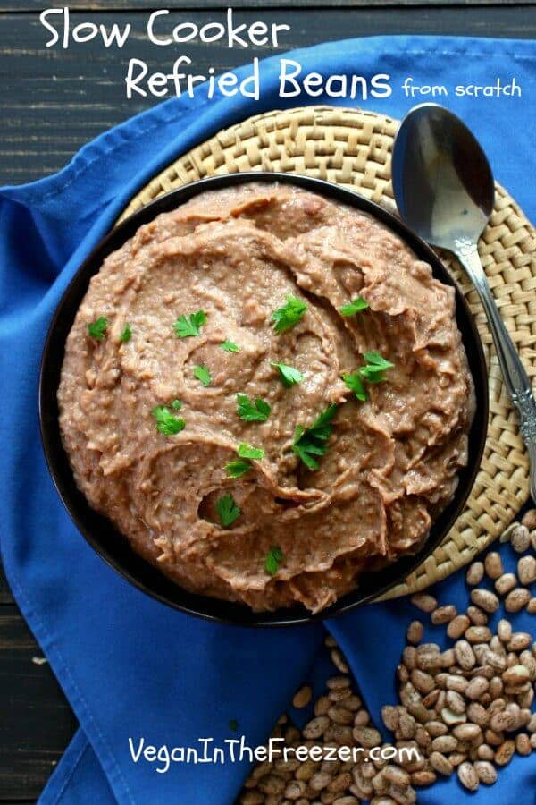 An overhead photo of Slow Cooker Refried Beans on a blue cloth with spilled dried beans.