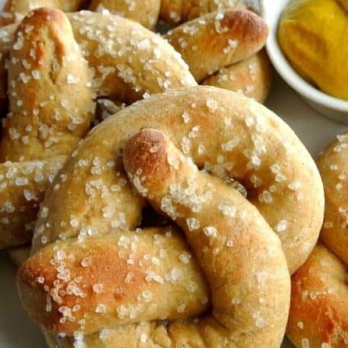 Close-Up photo of soft pillowy homemade giant soft pretzels. A little bit of mustard is in the corner.