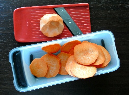 Sweet potatoes are being sliced thinly with a mandoline.