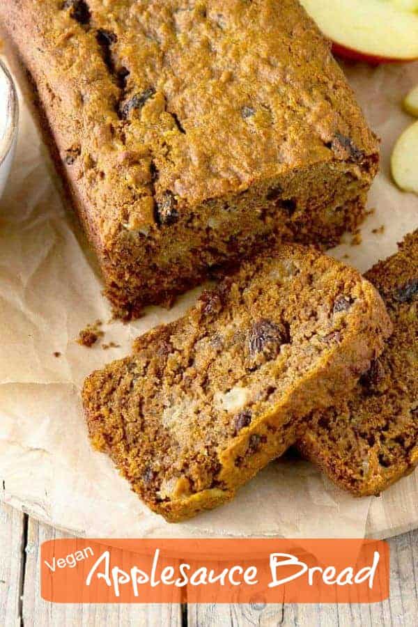 An overhead view of a loaf and two slices of golden brown applesauce bread.